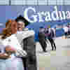 Student and reletive hugging after collecting graduation certificate