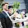 Female graduate with ceremonial flowers.