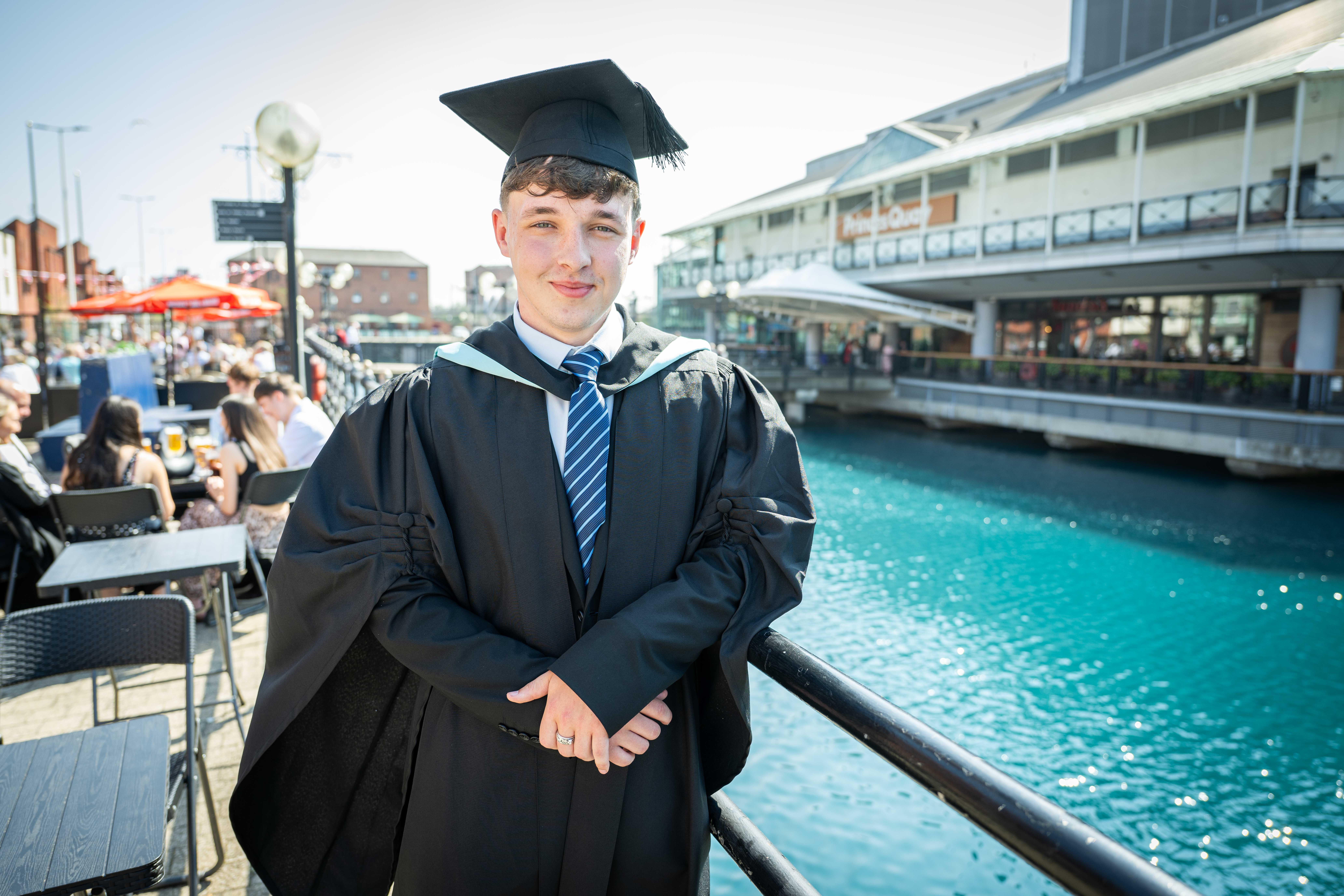 Graduate posing outside Princes Quay shopping centre. 