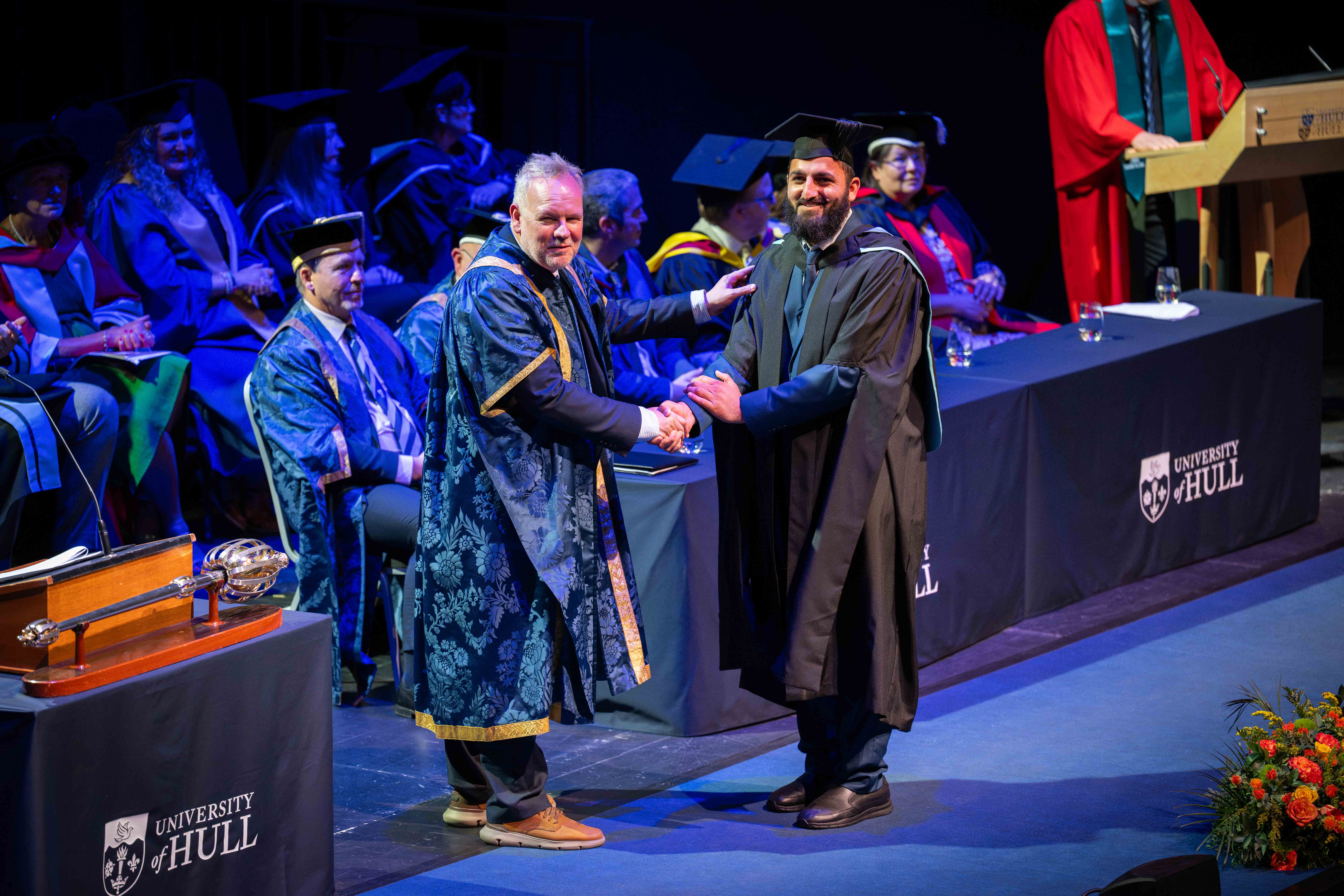Graduate shaking the hand of Vice Chancellor Tom Lawson.