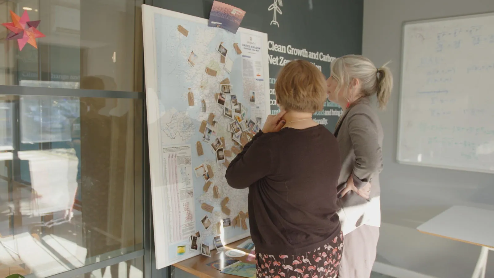 Two people in discussion in front of a map