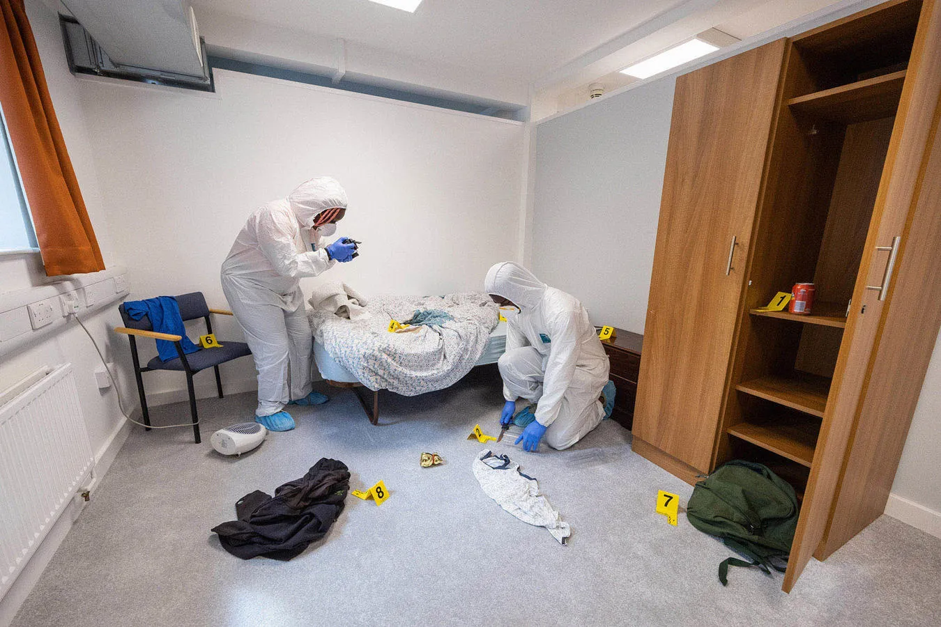 Students in a white protective suit using the crime scene lab