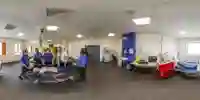 Students gather round a dummy laid on a stretcher as they practise in a critical care room