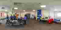 Students gather round a dummy laid on a stretcher as they practise in a critical care room