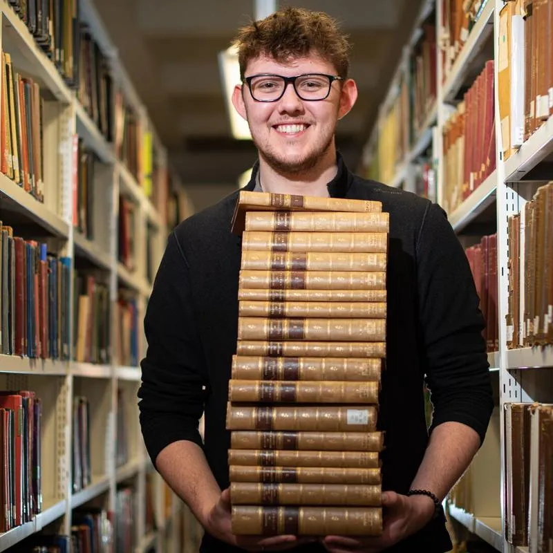 Student stood with a pile of books