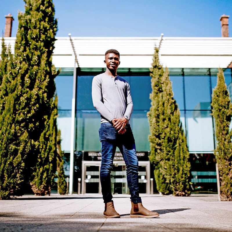 Student stood in front of Hull university on a sunny day.