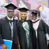 Three robed students posing for graduation photo