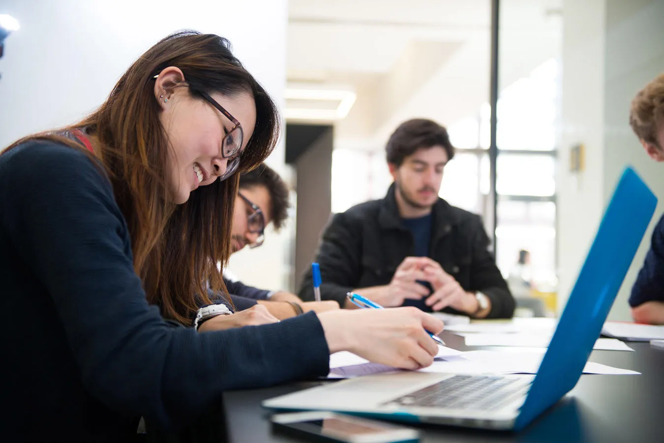 A student working at a desk in a group
