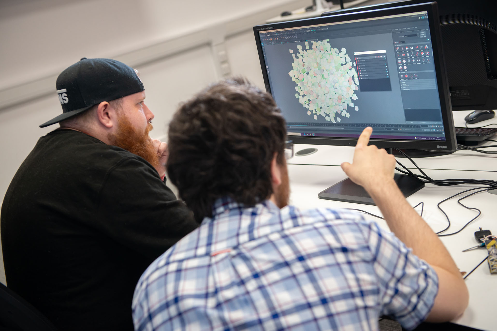 Student and lecturer creating 3D render on a PC