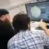 Student and lecturer creating 3D render on a PC