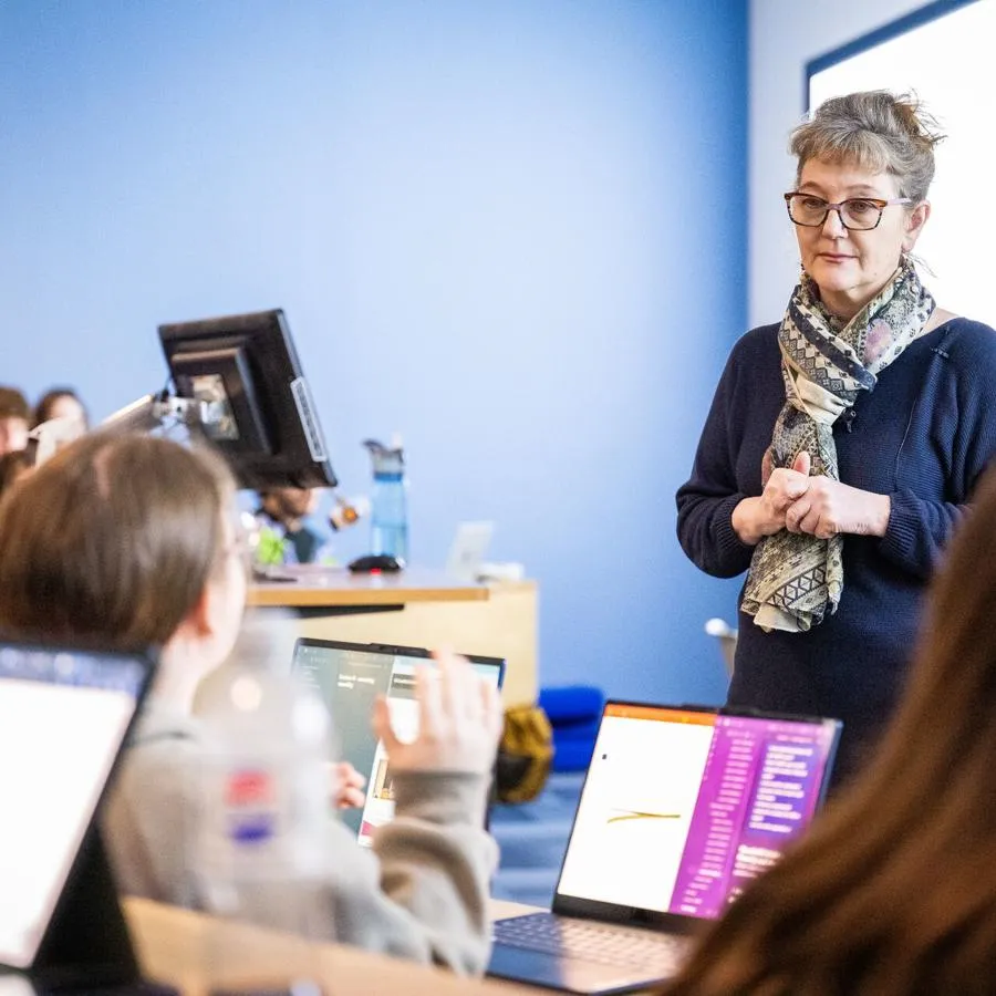 A lecturer listening to a group of students