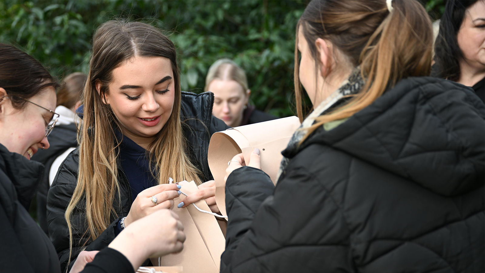 Students outside holding paper and string