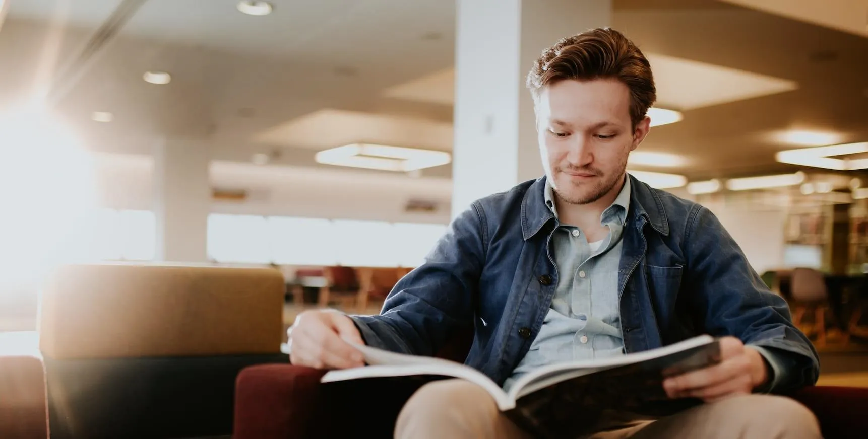Ethan Harding reading a book in the Brynmor Jones Library