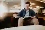 Ethan Harding reading a book in the Brynmor Jones Library