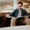 A student sat reading a large book in the library