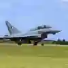 Fighter jet landing with brake parachute on airfield