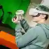 Young person with VR headset with their arms upright in a colourful room with green walls