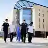 Health Students in NHS uniforms walking by the Allam Medical Building