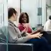 Students talk in a university foyer seating area