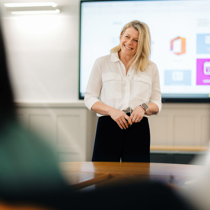 A lecturer smiling while hosting a seminar in the Business School