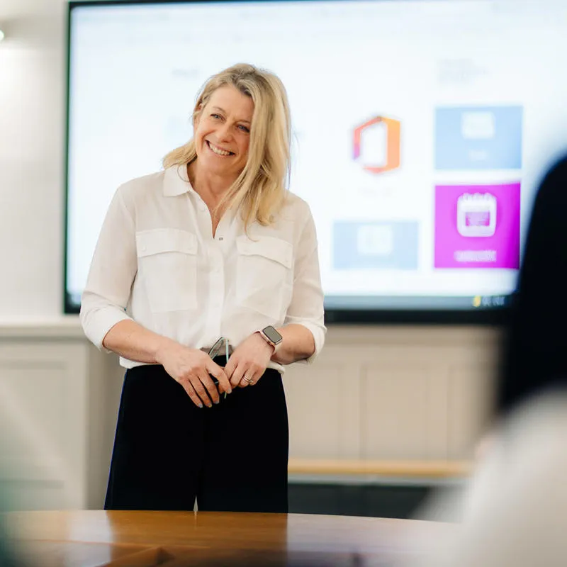 A lecturer smiling while hosting a seminar in the Business School