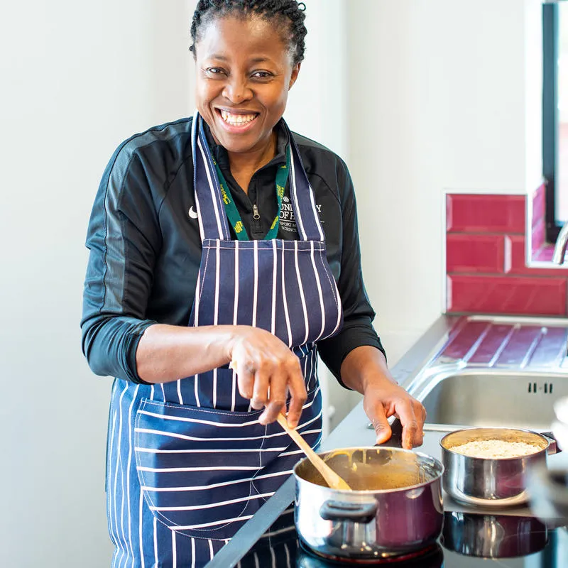 Student cooking on a hob.