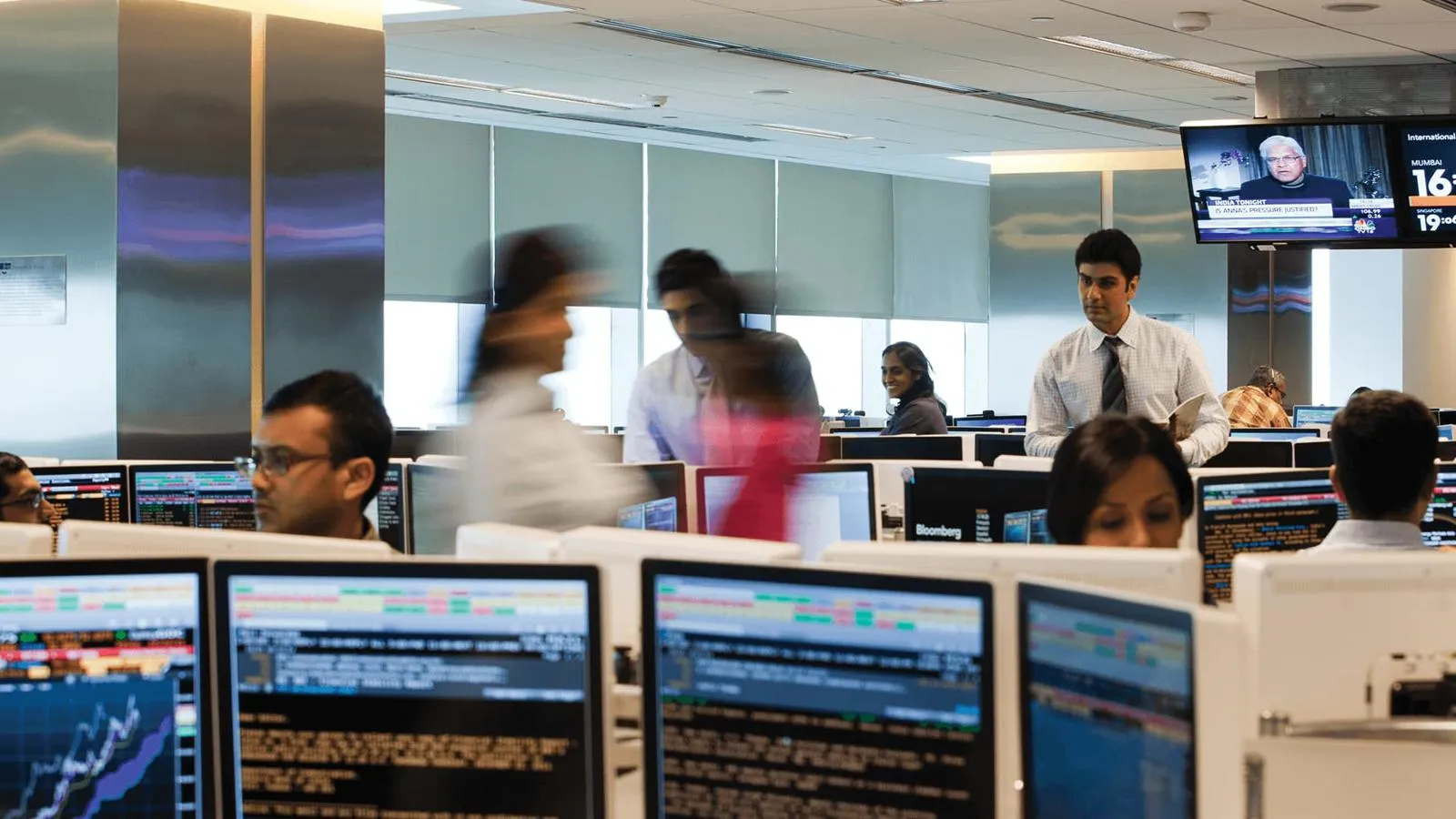 A busy office, with computers displaying financial data