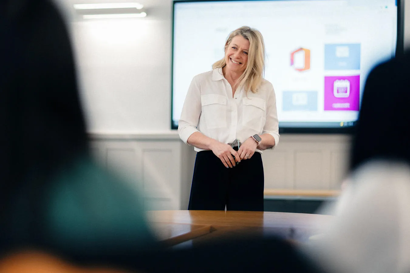 Lecturer teaching a class in front of an electric wipeboard