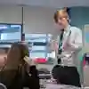 An Education Studies student stood at the front of a class talking to two school pupils during a placement
