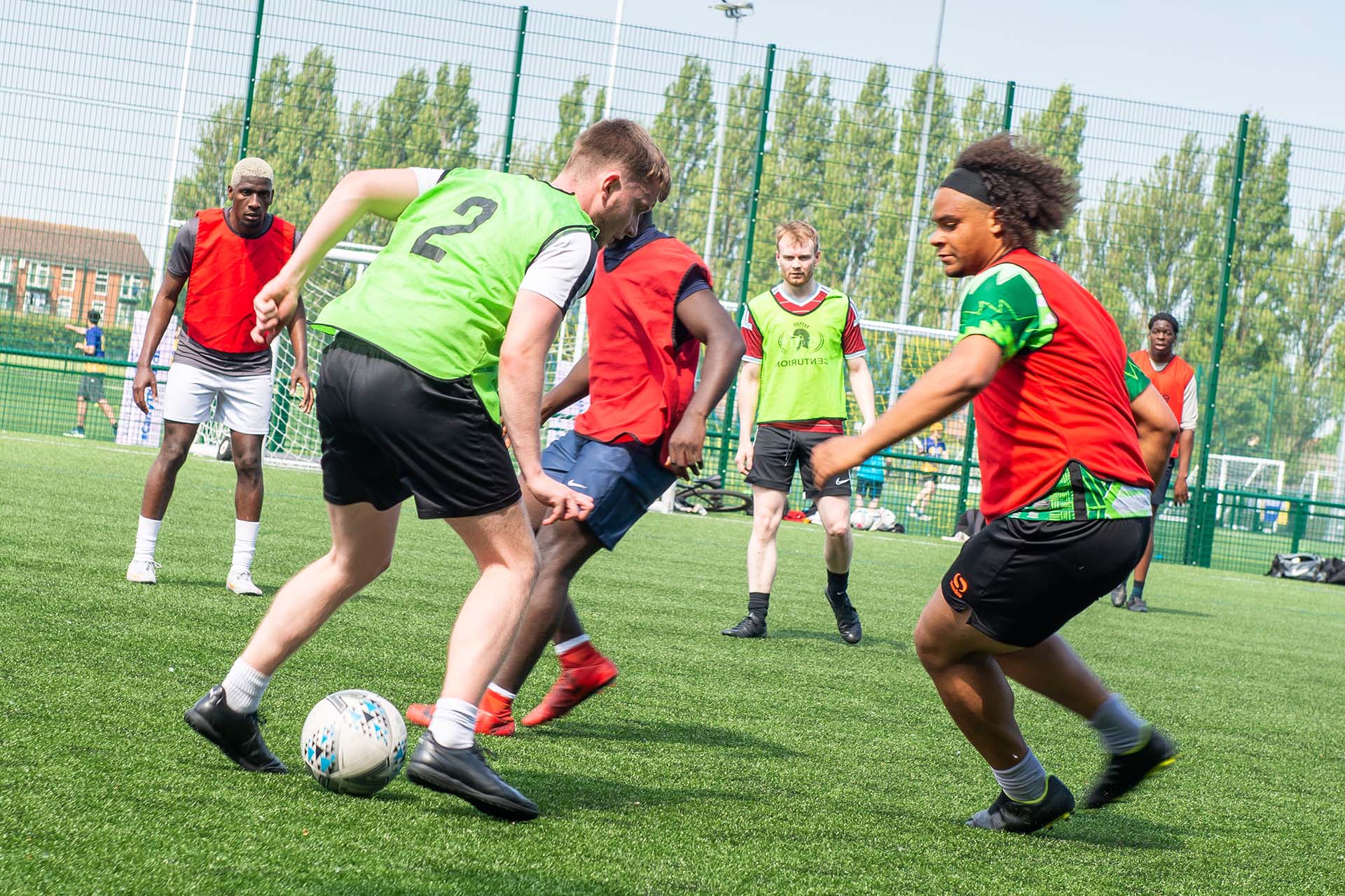 Students playing football on an outdoor pitch