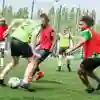 Students playing football on an outdoor pitch