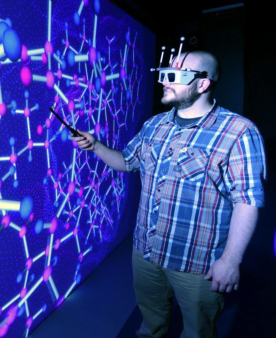 A student wearing a virtual reality headset working in the HIVE room
