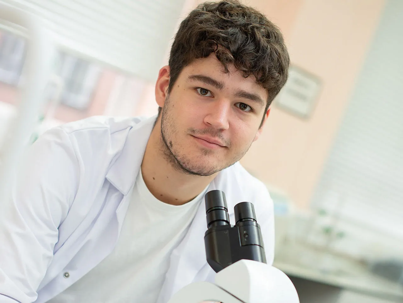 Student working with a microscope in a lab