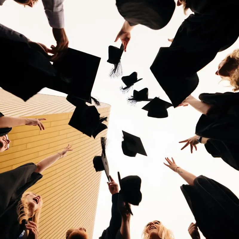 graduation image of hats being thrown in the air - view from underneath