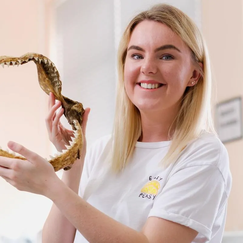 girl holding a shark jawbone