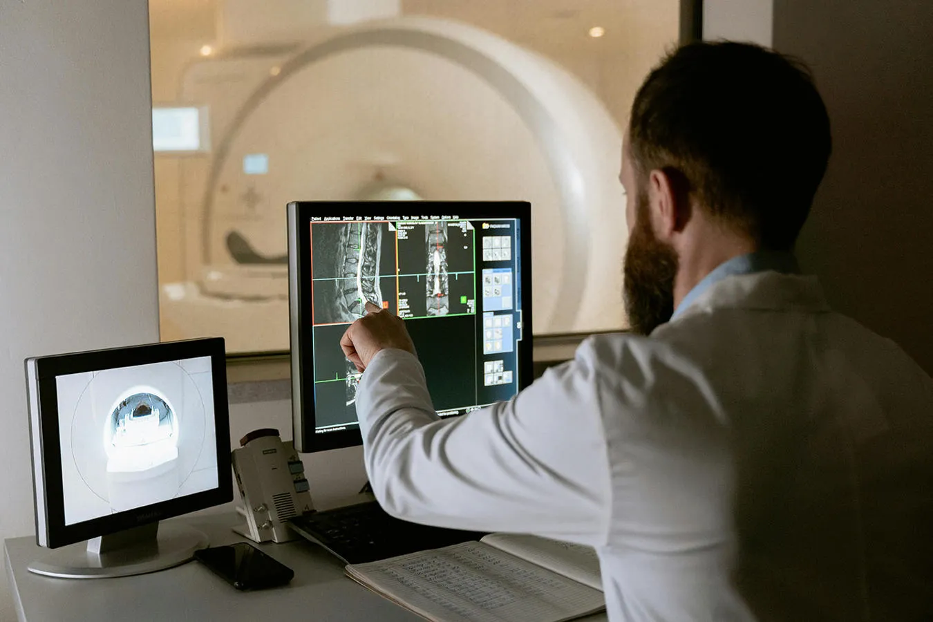 Man sitting looking at health diagnostic images on a computer screen