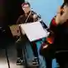 Three people playing string instruments on stage
