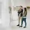 Two students stand alongside each other look at an exhibit in a gallery
