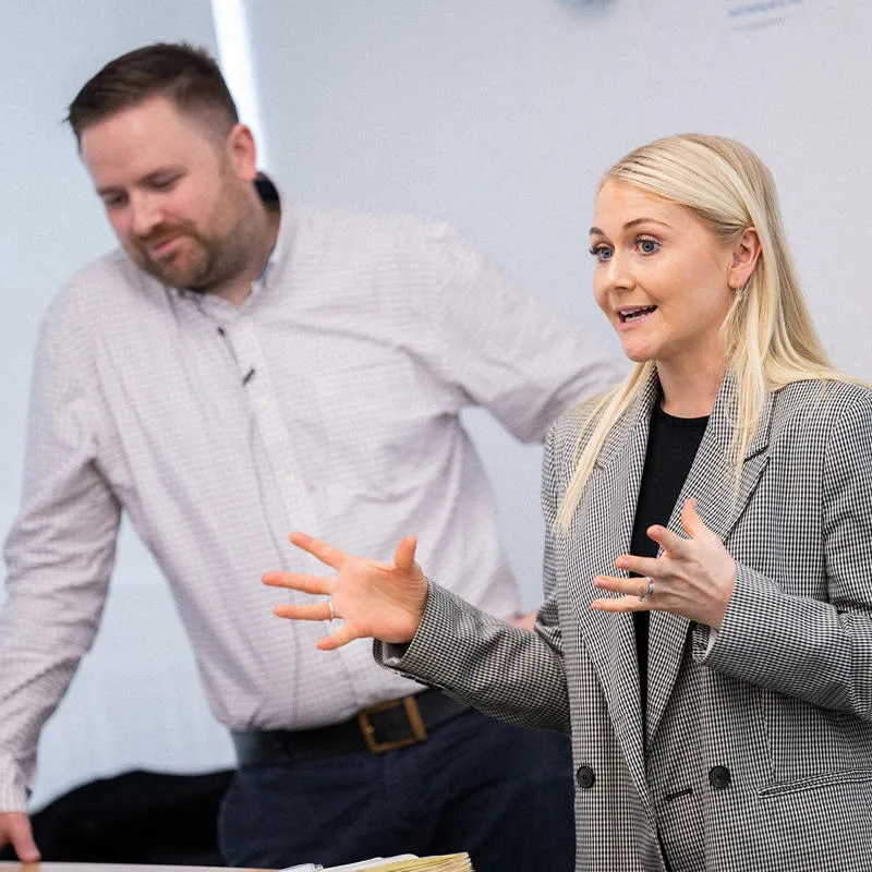 A speaker presents a talk while another person looks on