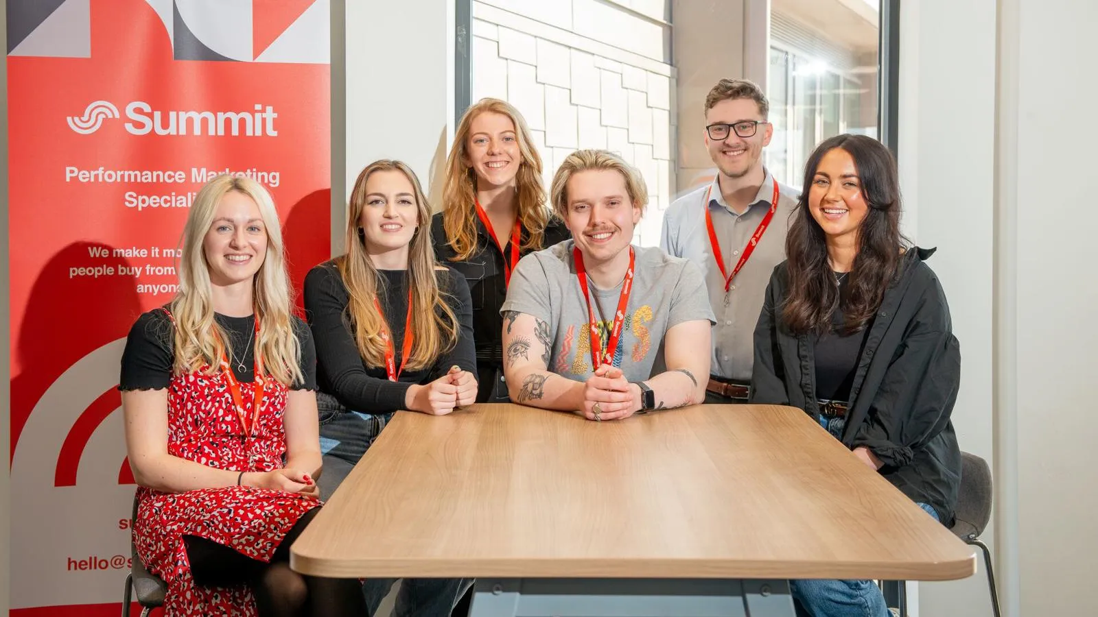 A group of students on placement sat smiling around a table