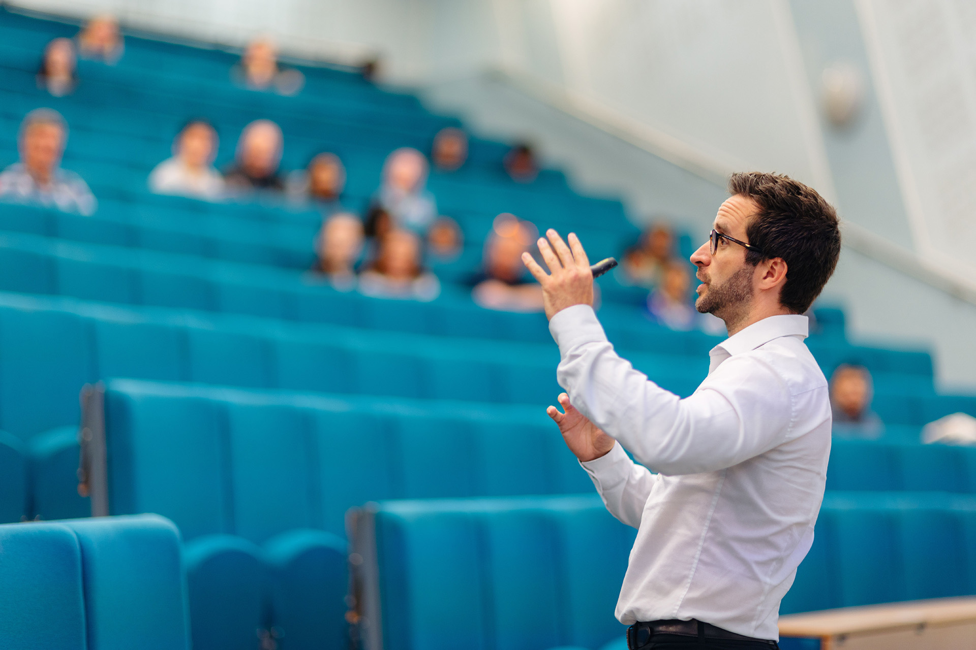 Business School lecturer Tom Hoyland is mid flow in front of a class in a large lecture theatre