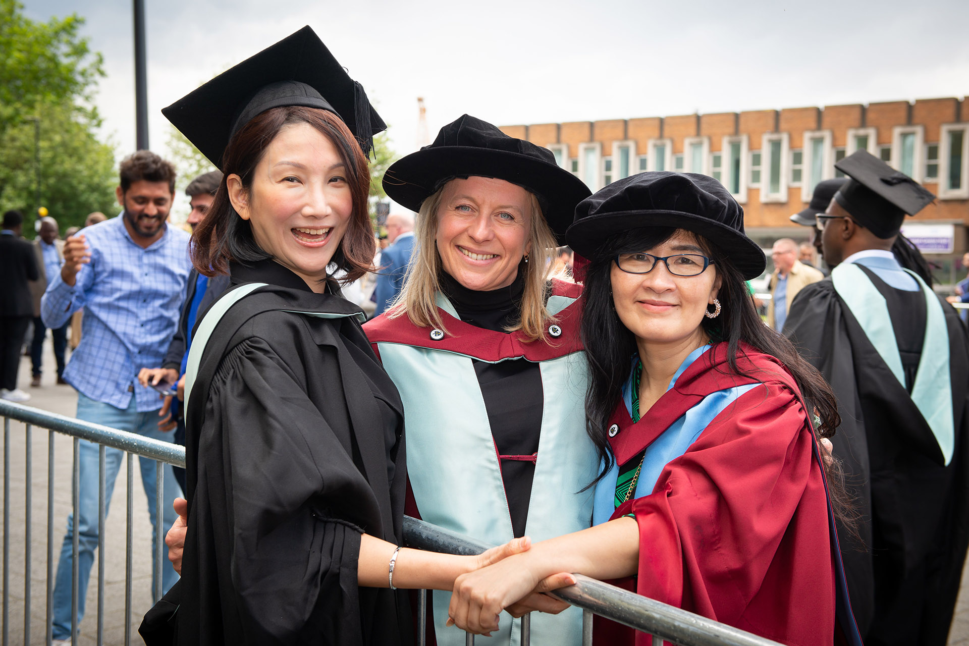 An academic poses with two graduands on their graduation day in Hull