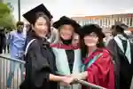 An academic poses with two graduands on their graduation day in Hull