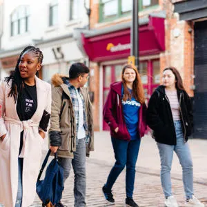 5 students walking down Humber street while Talking.