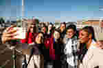 A group of smiling students takes a selfie at Hull Marina