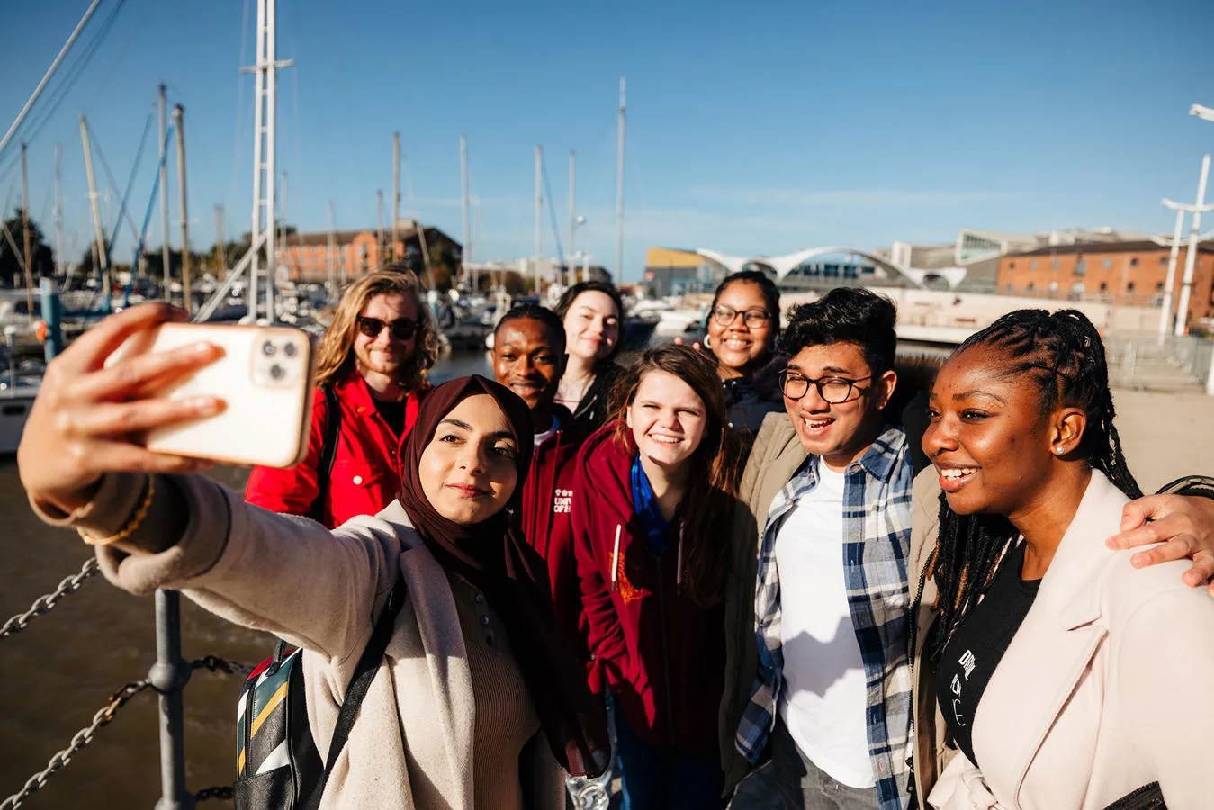 A group of smiling students takes a selfie at Hull Marina