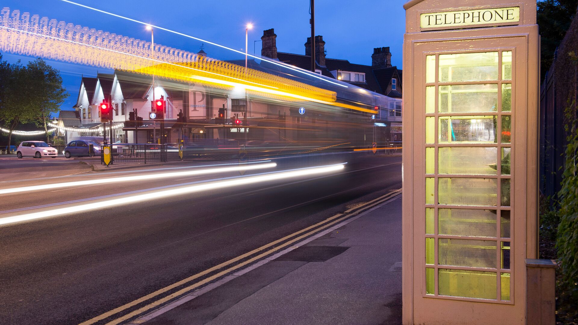 cream kcom telephone box from hull at night time