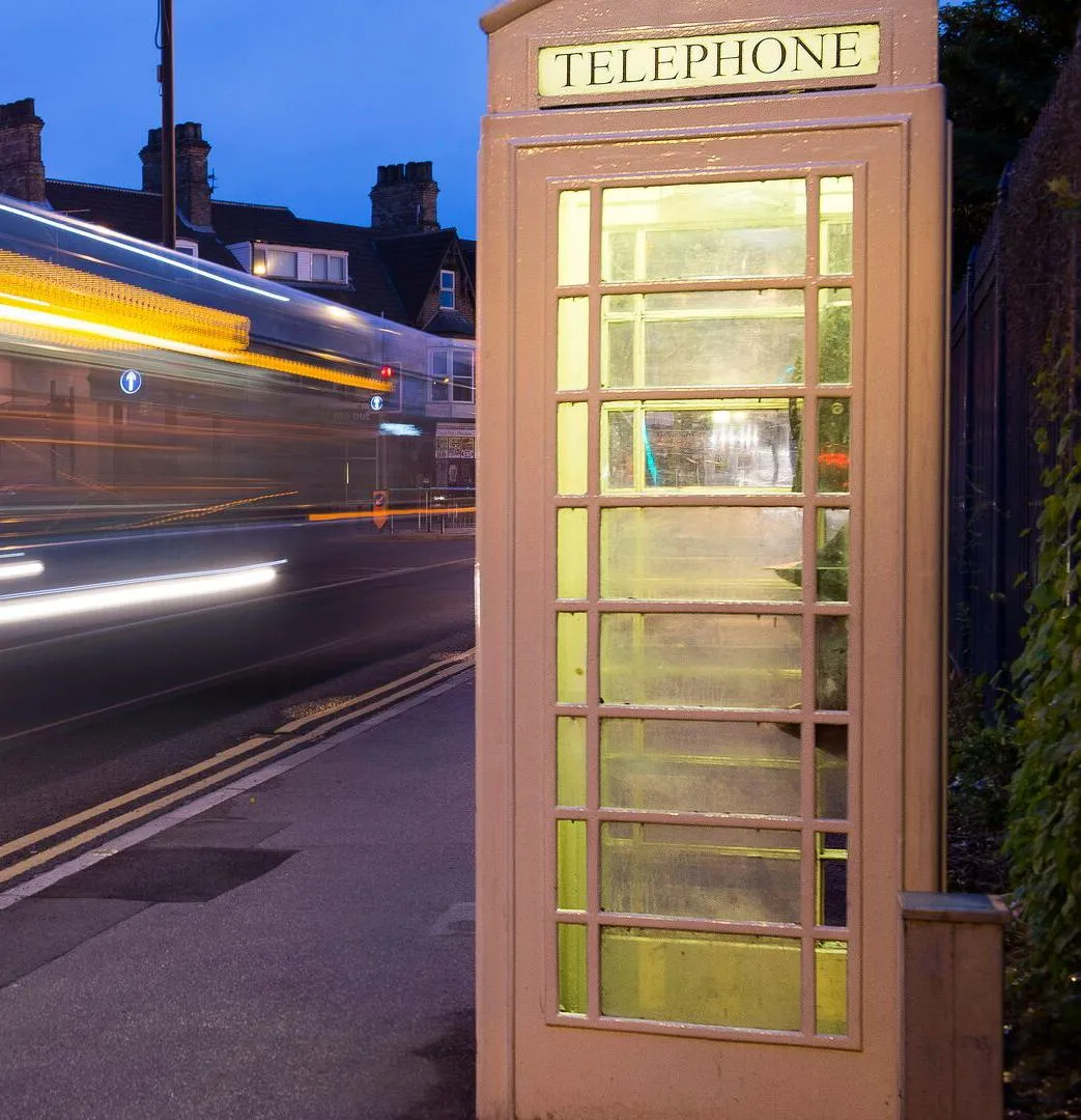 cream kcom telephone box from hull at night time