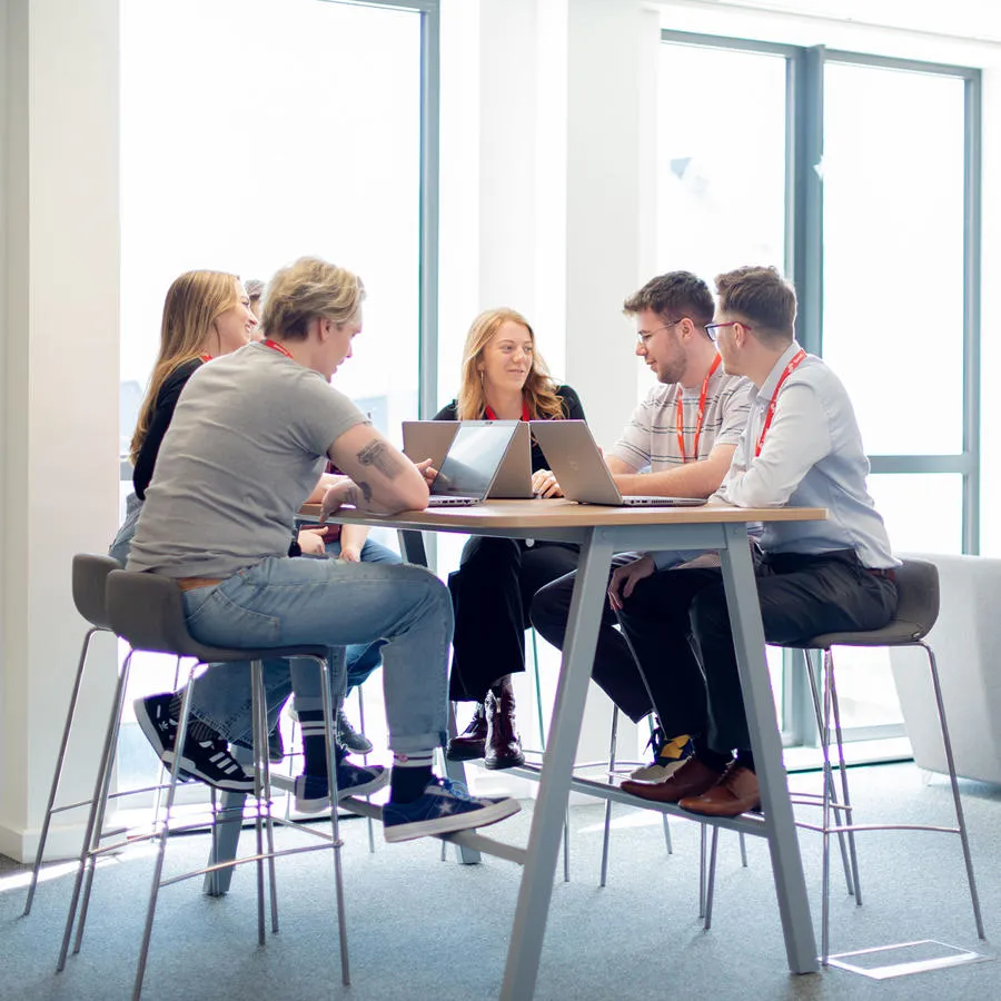Students sitting around a table in the Business Lounge