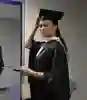 Female University of Hull graduate wearing a black cap and gown